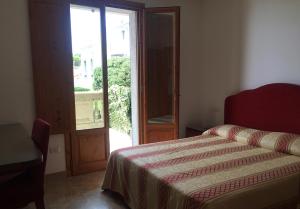 a bedroom with a bed and an open door at Appartamenti fronte mare in Castiglioncello