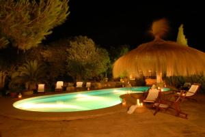 a swimming pool at night with chairs and a umbrella at Son Mercadal in Porreres
