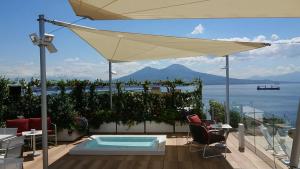 a patio with an umbrella and a swimming pool at Grand Hotel Vesuvio in Naples