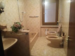 La salle de bains est pourvue de toilettes, d'un lavabo et d'un miroir. dans l'établissement Spazioso appartamento indipendente, à Apecchio