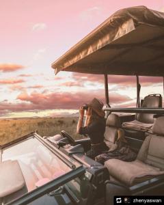 a person taking a picture of a safari in a vehicle at Nambiti Plains in Nambiti Private Game Reserve