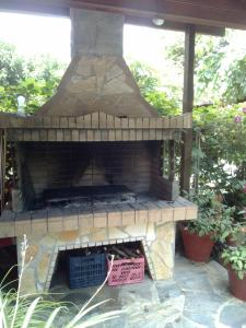 an outdoor brick oven with a sign in a yard at Anastasia Chalatsogianni Rooms in Paralia Panteleimonos