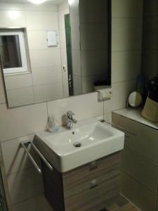 W łazience znajduje się biała umywalka i lustro. w obiekcie Bungalow am Werratal Radwanderweg w mieście Breitungen