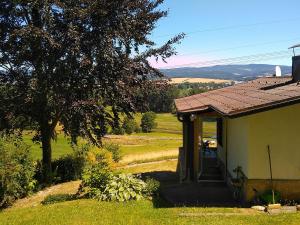 a small house with a view of a field at Bungalow am Werratal Radwanderweg in Breitungen