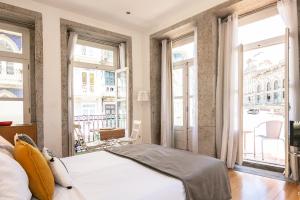 a bedroom with a bed and large windows at Stay in Apartments - S. Bento in Porto
