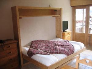 1 dormitorio con litera y marco de madera en Studio Forclaz, en Le Grand-Bornand