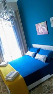 - une chambre bleue avec un lit et une fenêtre dans l'établissement Corte Degli Aranci House, à Paterno