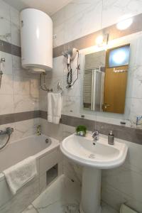 a bathroom with a sink and a tub and a mirror at Apartment Barby - Deluxe in Banja Luka +29 photos