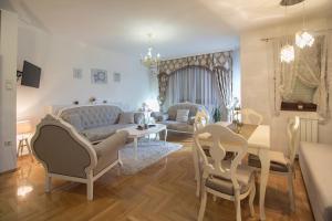 a living room with a couch and a table and chairs at Apartment Barby - Deluxe in Banja Luka