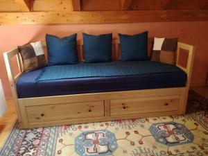 een bed met blauwe kussens in een kamer bij Villa Pircher in Dobbiaco