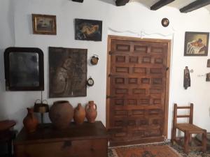 Habitación con puerta de madera y jarrones sobre una mesa. en Fonda Del Tozal, en Teruel