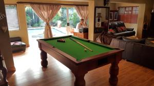 a living room with a pool table and a woman at Walmer Heights Guest House in Port Elizabeth