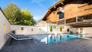 une maison avec une piscine à côté d'un bâtiment dans l'établissement Relais de la Sarvaz, à Saillon