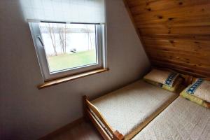 a small room with two beds and a window at Kaukiškė in Antalksnė