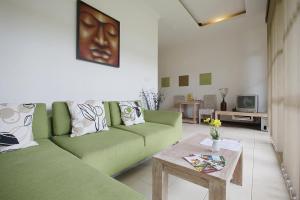 een woonkamer met een groene bank en een tafel bij The Studio in Seminyak