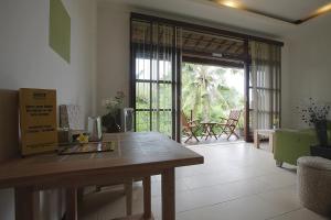 a dining room with a wooden table and a patio at The Studio in Seminyak