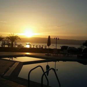 een zonsondergang boven een zwembad met zonsondergang bij Utopia Kavos in Kavos