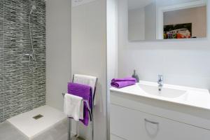 トッサ・デ・マールにあるNS Apartamentsの白いバスルーム(紫色のタオル、シンク付)