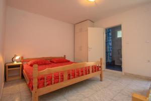 a bedroom with a bed with red pillows on it at Robinson Monte Cristo in Bogomolje