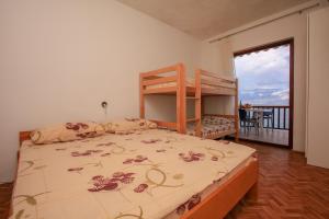 a bedroom with a bunk bed and a balcony at Robinson Monte Cristo in Bogomolje