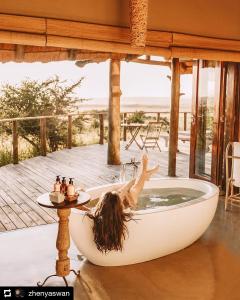 a woman laying in a bath tub in a house at Nambiti Plains in Nambiti Game Reserve