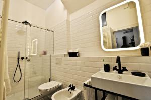 bagno con lavandino, servizi igienici e specchio di A’ Terravecchia Loft a Grottole