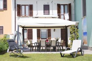 a patio with a table and chairs and an umbrella at La Casa di Cristina in Arona