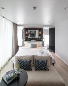 ein großes Schlafzimmer mit einem großen Bett und einem Sofa in der Unterkunft Apartelle Jatujak Hotel in Bangkok