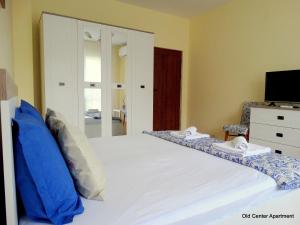 a bedroom with a large white bed and a mirror at Old Center Apartment in Ruse