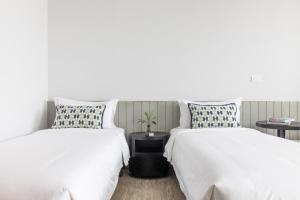 two beds sitting next to each other in a room at Apartelle Jatujak Hotel in Bangkok