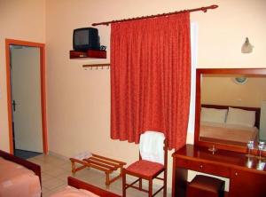 um quarto de hotel com uma cama e uma secretária e um quarto em Apollon Hotel em Tyros