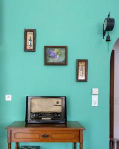 Dimitris Luxury Apartment في كيراموتي: راديو قديم جالس على طاولة مع صور على الحائط