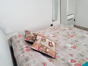 Una cama con dos almohadas encima. en Vincent's home, en Nápoles