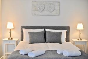 a bed with two pillows on it with two lamps at Apartamenty Porto Eli in Rowy