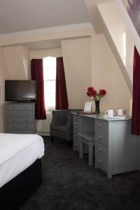 a hotel room with a bed and a desk and a chair at Castle Park Hotel in Leicester