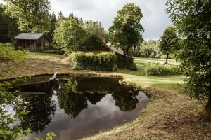 a reflection of a cottage in a pond at Avoti in Līgatne