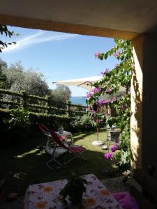 a patio with a table and a chair and flowers at Apartment Fasano Sopra in Gardone Riviera