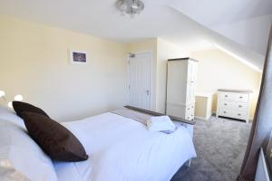 a bedroom with a large white bed and a dresser at Hillyard Mews in Newcastle