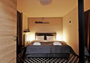 a bedroom with a bed with a clock on the wall at Villa Nova in Białystok