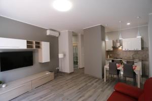 a living room and kitchen with a table and chairs at SIROIKIA luxury apartments in Siracusa