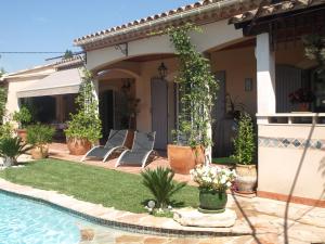 einen Hinterhof mit einem Pool und einem Haus in der Unterkunft Villa Fleurie in Les Angles Gard