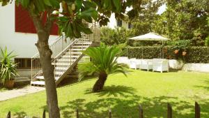 a garden with a staircase and chairs and an umbrella at I Sogni di Morfeo in Termoli