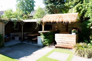 a small house with a thatch roof and a table at Genesis Voorschoten in Voorschoten