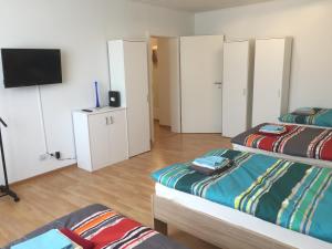 ザールブリュッケンにあるMonteur-Wohnung, City-Unterkunft "Ponderosa"のベッド2台、薄型テレビが備わる客室です。