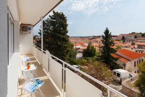 einen Balkon mit einem Stuhl und Stadtblick in der Unterkunft Botun Apartman free parking in Pula