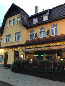 a building with a sign on the front of it at Apartamenty Classico na deptaku in Karpacz