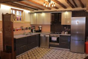 a kitchen with black cabinets and a stainless steel refrigerator at Melekli Konak in Amasya
