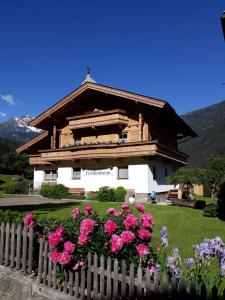 a house with a fence and flowers in front of it at Ferienwohnungen Fichtenheim in Mayrhofen