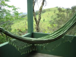 a hammock in a room with a view at Poente Guest House in Conceição da Ibitipoca