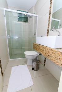 a bathroom with a toilet and a sink and a shower at Hotel Paraiso in Correia Pinto